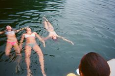 three people are swimming in the water together