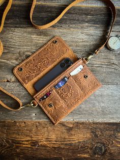 a cell phone and wallet sitting on top of a wooden table