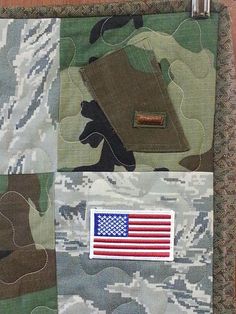 an american flag patched on the side of a camouflaged fabric material with metal pins