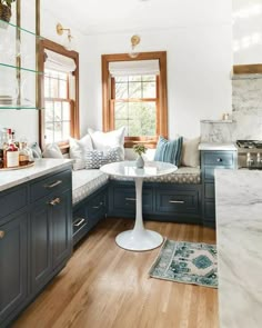 a kitchen with blue cabinets and white counter tops, along with a marble topped breakfast nook