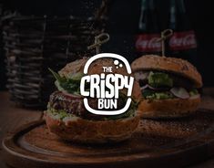 two burgers sitting on top of a cutting board with the words crispy bun