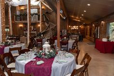 a dining room with tables and chairs covered in purple tablecloths, decorated with greenery