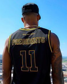 a man wearing a black jersey with the number 11 on it looking out over a city