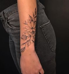 a woman's arm with a flower tattoo on the left side of her arm