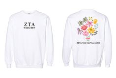 a white sweater with flowers on it and the words zita moms written in black