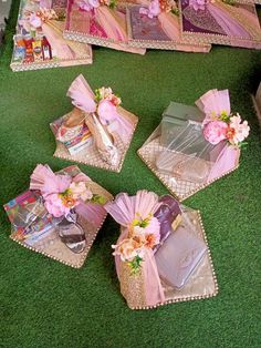 pink flowers are placed in small baskets on the floor next to other items that have been wrapped around them