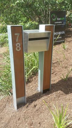 a metal mailbox sitting on top of a dirt field