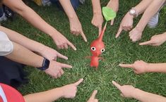 a group of people standing in the middle of a circle with their hands pointing at something