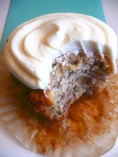 a cupcake with white frosting on it sitting on top of a paper plate