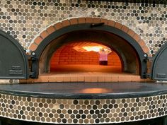 a brick oven with an open door on the outside