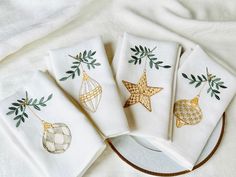 four white napkins with gold ornaments on them