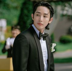 a young man in a tuxedo looks at the camera