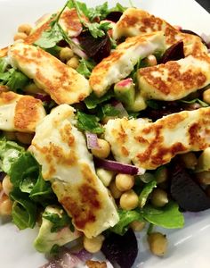 a white plate topped with salad and tofu