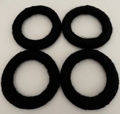 four black rubber rings on a white surface