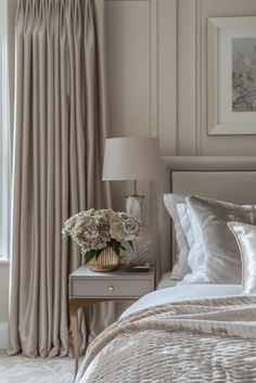 a bed with white sheets and pillows next to a window