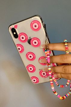 a person holding a cell phone with pink and white donuts on the back of it