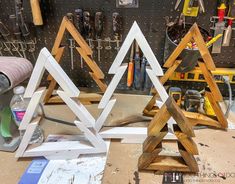 three wooden christmas trees sitting on top of a workbench