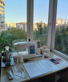 a sewing machine sitting on top of a table next to a window