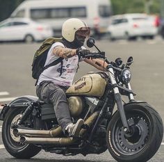 a man riding on the back of a motorcycle down a street