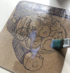 a drawing on a piece of cardboard with a brush