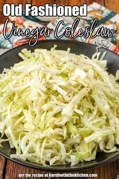 an old fashioned vinegar coleslaw recipe in a black bowl on a wooden table