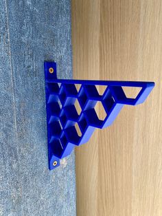 a blue shelf sitting on the side of a wooden floor next to a wall with holes in it