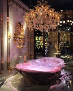 a pink bowl sitting in front of a chandelier