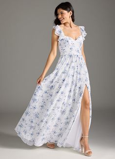 a woman wearing a white dress with blue flowers on it and a thigh high slit