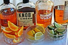 several bottles and glasses filled with different types of alcohol on top of a table cloth