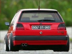 a red golf gti is parked on the side of the road with it's license plate