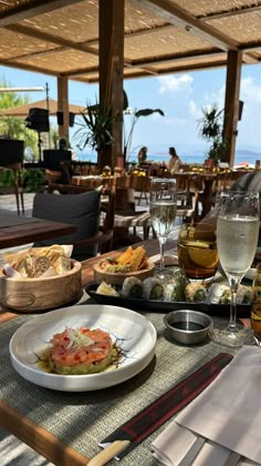 a table topped with plates of food and glasses of wine