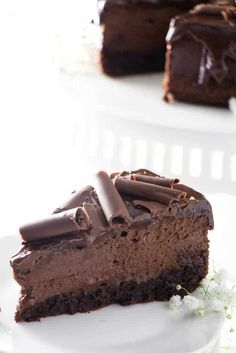 a piece of chocolate cake on a plate with one slice cut out and the rest half eaten