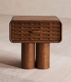 two wooden stools sitting side by side on a white surface, one with holes in the middle