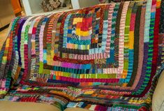 a large multicolored quilt on the back of a couch