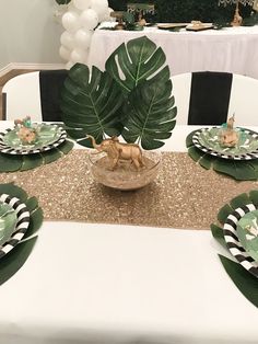 there is a table set with plates and place settings for an animal themed birthday party