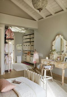 a bedroom with a bed, dresser and dressing table in it's center area