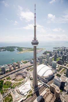 an aerial view of a large city with tall buildings in the foreground and a body of water behind it