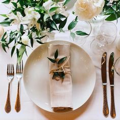 a place setting with napkins, silverware and flowers