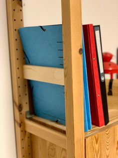 a wooden shelf with books and binders on it