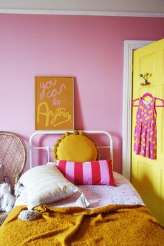 a bedroom with pink walls and yellow doors