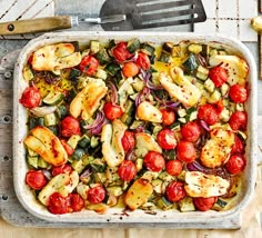 a casserole dish with tomatoes, zucchini and other vegetables