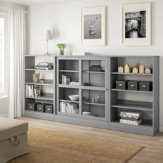 a living room filled with lots of gray bookshelves next to a white couch