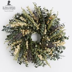 a wreath made out of dried flowers and greenery