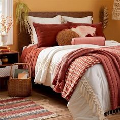 a bedroom with orange walls and white bedding