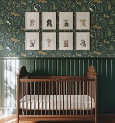 a baby's crib in the corner of a room with green wallpaper