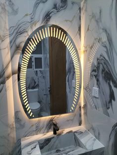 a bathroom with marble walls and a round mirror