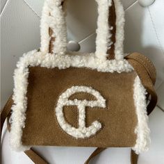 Iconic Unisex Telfar Bag Made In Collaboration With Ugg In Genuine Chestnut Suede With A Cuddly Shearling Trim. Bag Features Double Strap To Be Worn Cross-Body, Inlaid Shearling Telfar Logo, 100% Cotton Lining And Magnetic Snap Closure. Same Size As Our Small Shopping Bag. Small Is The Party-Bag + The Afterparty Too. Materials Outer: 100% Genuine Suede W/ Shearling Trim Lining: 100% Cotton Dimensions (Height 4 3/4", Width 6 5/8", Depth 3 1/8", Drop 21") Limited Edition | Sold Out In Stores Telfar Logo, The Afterparty, Ugg Bag, Telfar Bag, Chestnut Color, Party Bag, Womens Uggs, Chestnut, Bag Making