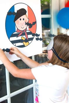 a woman is holding up a sign with an image of a pirate on it