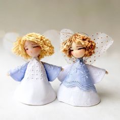 two little angel figurines standing next to each other