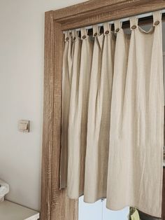 an open window with curtains hanging from it